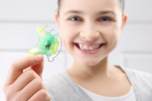 teenager holding their retainer