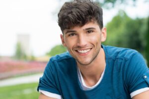 A teenage smiling outside.